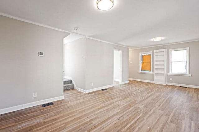 unfurnished room with visible vents, baseboards, stairs, light wood-type flooring, and crown molding