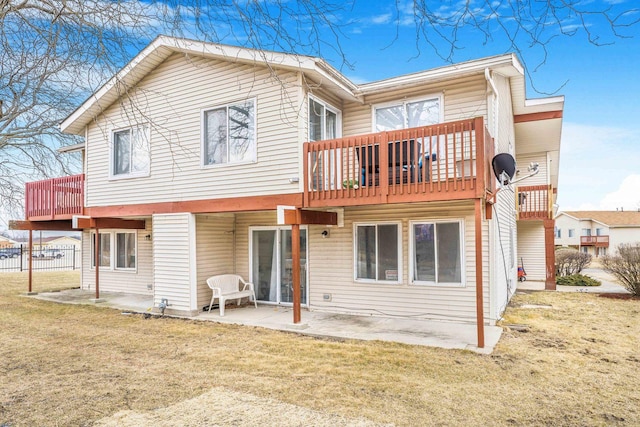 back of property with a yard, a deck, and a patio