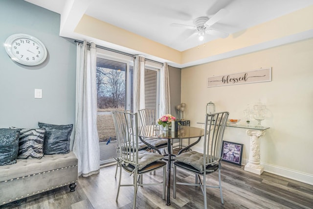 dining room with a ceiling fan, baseboards, and wood finished floors