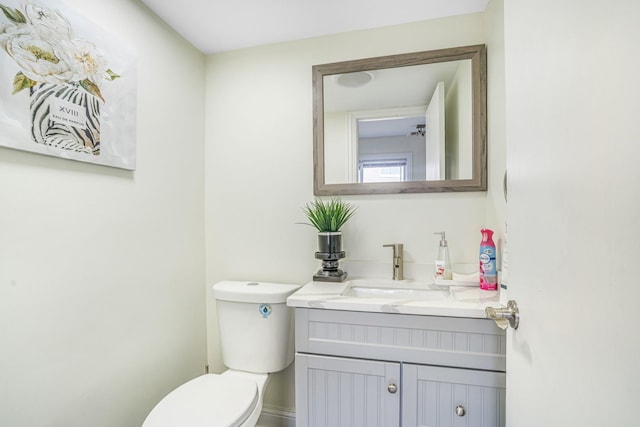 half bathroom with toilet and vanity