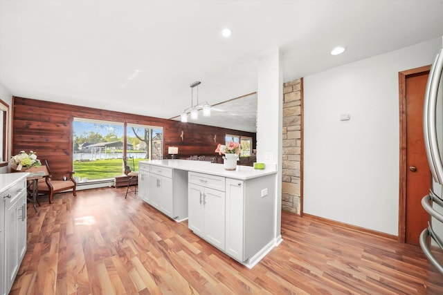 kitchen with light countertops, light wood-type flooring, a water view, and recessed lighting