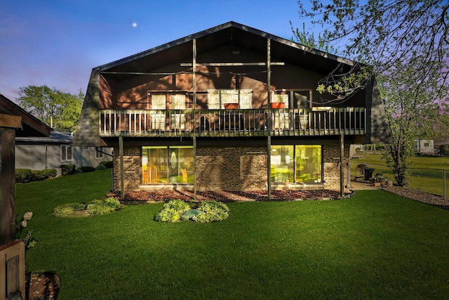 back of property with brick siding and a yard