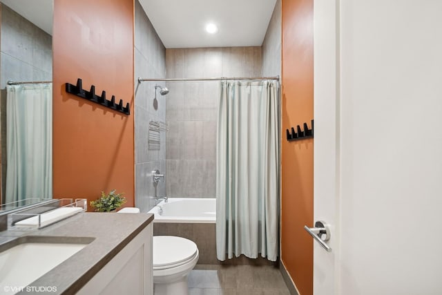 full bath with tiled shower / bath combo, vanity, toilet, and tile patterned floors