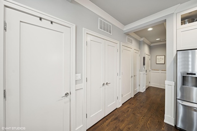 hallway with dark wood-style floors, visible vents, crown molding, and recessed lighting