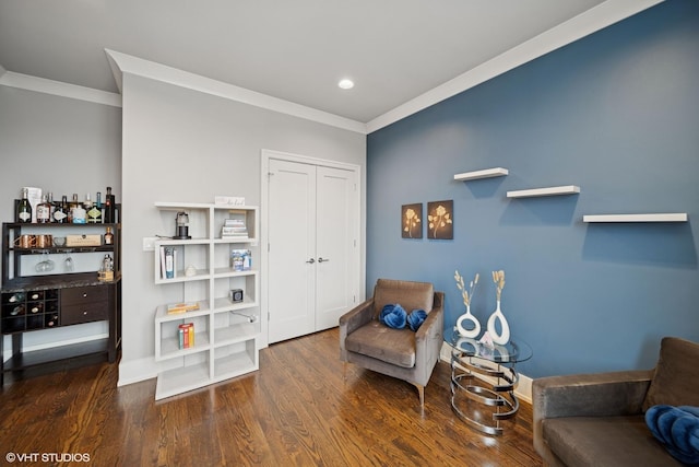 sitting room featuring ornamental molding, wood finished floors, and baseboards