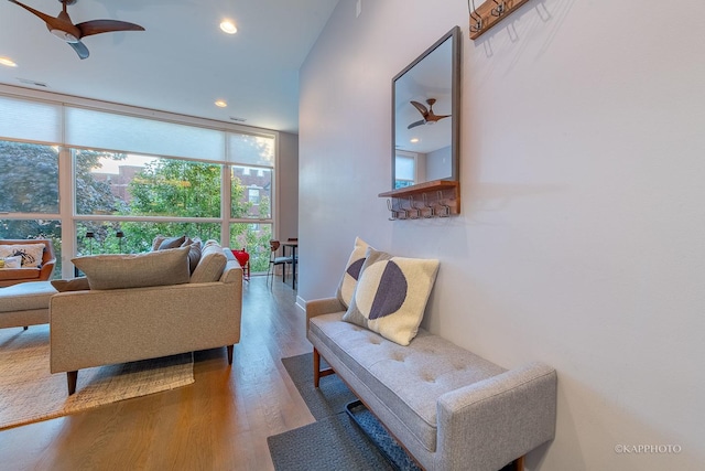 living area featuring recessed lighting, visible vents, a ceiling fan, wood finished floors, and a wall of windows