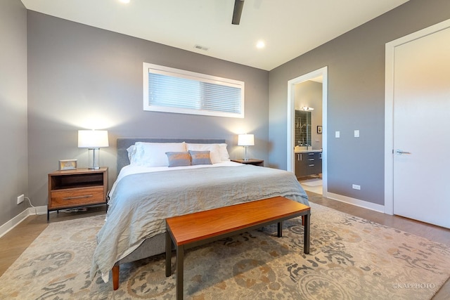 bedroom with baseboards, a ceiling fan, connected bathroom, wood finished floors, and recessed lighting