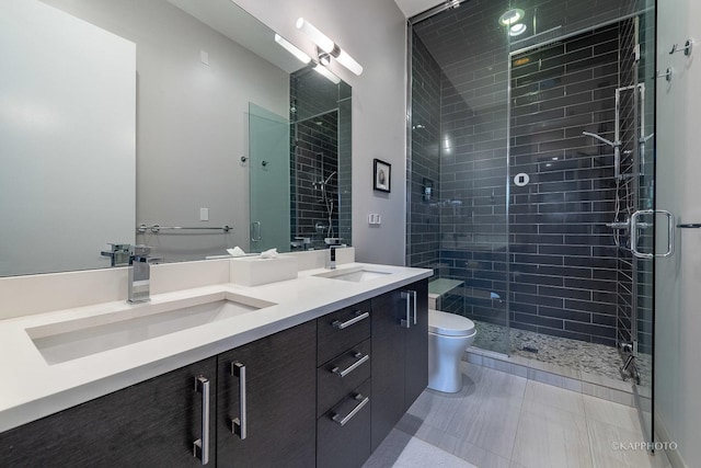 full bathroom with a stall shower, a sink, toilet, and double vanity