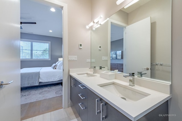 bathroom featuring double vanity, wood finished floors, a sink, and ensuite bathroom