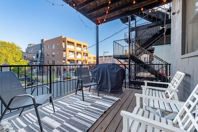 wooden terrace featuring stairway and a grill