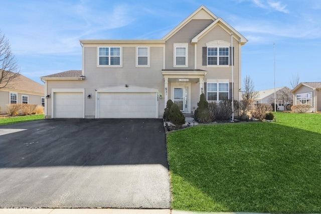 traditional-style home featuring a front yard, an attached garage, and driveway