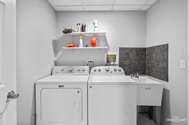 washroom with a sink, laundry area, and washing machine and clothes dryer