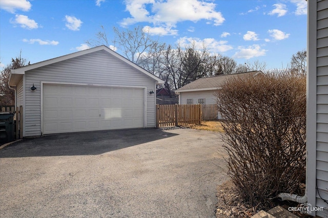 detached garage featuring fence