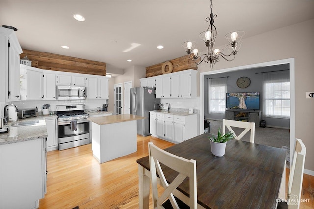 dining space with a chandelier, recessed lighting, and light wood-style floors