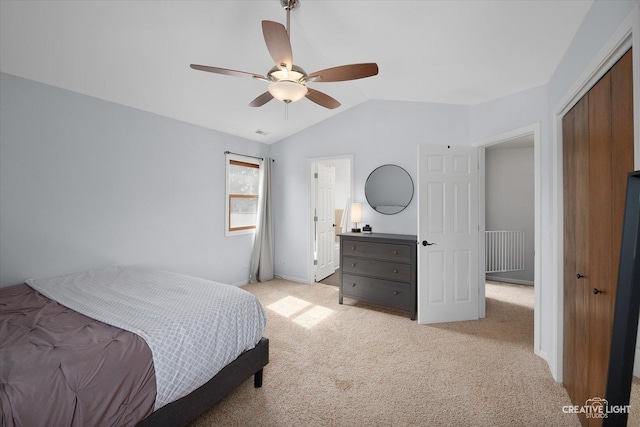 bedroom with visible vents, ceiling fan, light colored carpet, lofted ceiling, and a closet