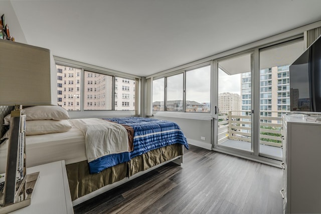 bedroom featuring access to exterior, wood finished floors, and baseboards