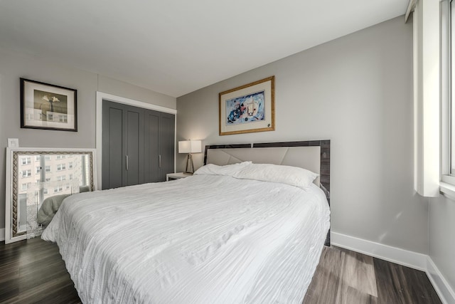 bedroom featuring a closet, baseboards, and dark wood-style floors