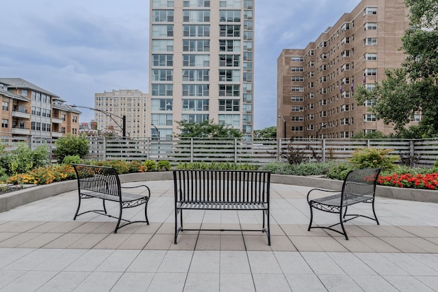 view of patio / terrace featuring a view of city and fence