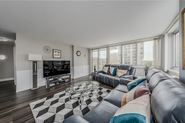 living area with plenty of natural light, wood finished floors, and a wainscoted wall