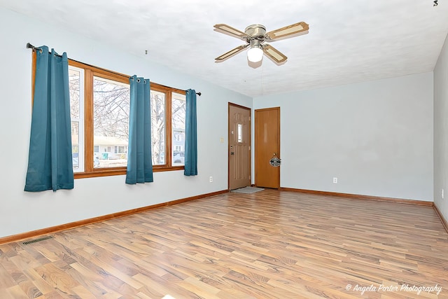 unfurnished room featuring visible vents, light wood-style flooring, and baseboards