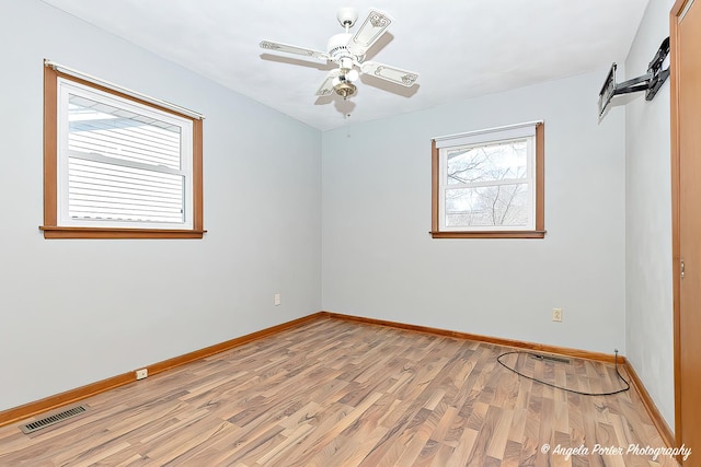 unfurnished room with light wood finished floors, baseboards, visible vents, and a ceiling fan