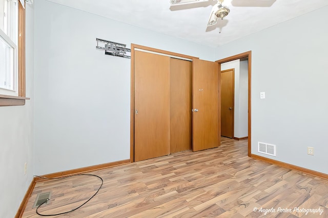 unfurnished bedroom with baseboards, a closet, visible vents, and light wood-style floors