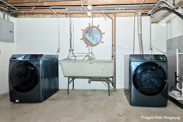 laundry area with laundry area, electric panel, a sink, and independent washer and dryer