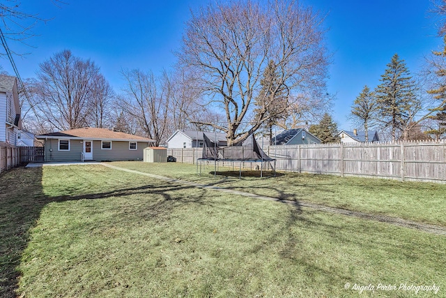 view of yard featuring a trampoline and a fenced backyard