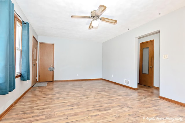 spare room with visible vents, a ceiling fan, light wood-style flooring, and baseboards