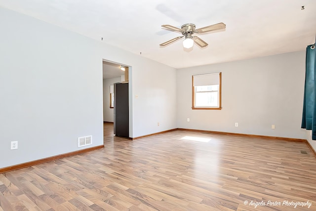 empty room with baseboards, visible vents, and light wood-style floors