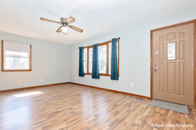 foyer entrance with light wood-style floors, baseboards, visible vents, and ceiling fan