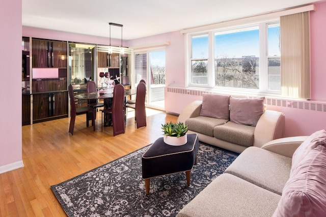 living area with light wood-type flooring and baseboards