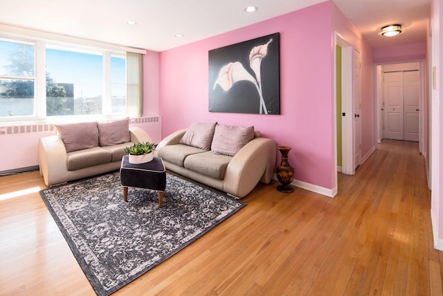 living room with recessed lighting, baseboards, radiator, and wood finished floors