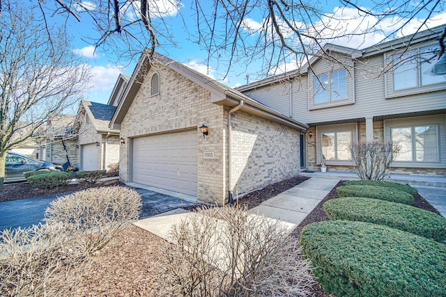 view of front of property with a garage, brick siding, and driveway