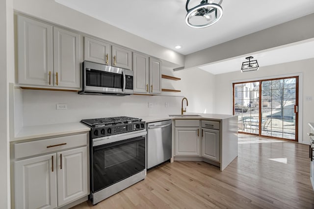 11905 Sterling Dr, Orland Park, IL 60467 - kitchen featuring light countertops, a sink, a peninsula, stainless steel appliances, and light wood-style floors