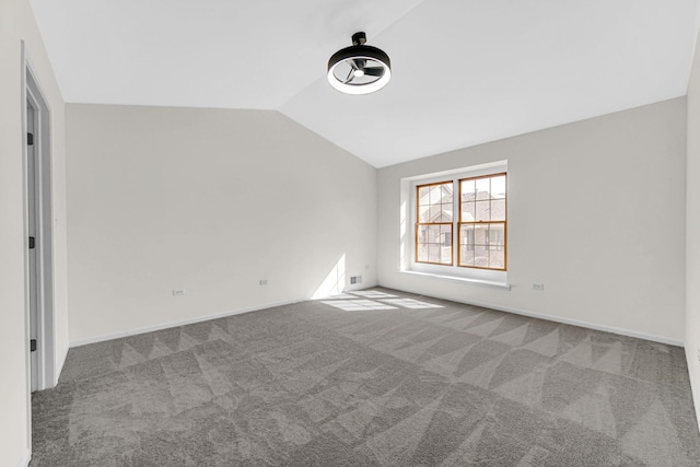 carpeted spare room with lofted ceiling, visible vents, and baseboards