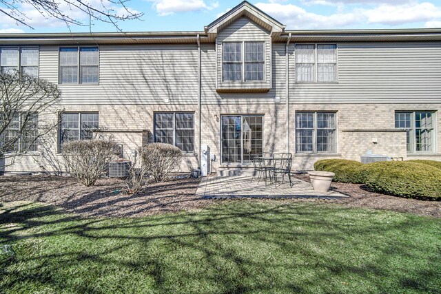 11905 Sterling Dr, Orland Park, IL 60467 - rear view of house featuring brick siding, central AC unit, a patio area, and a lawn