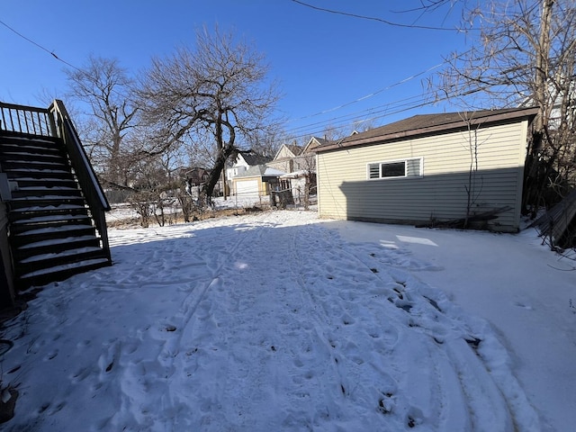 snowy yard featuring stairway