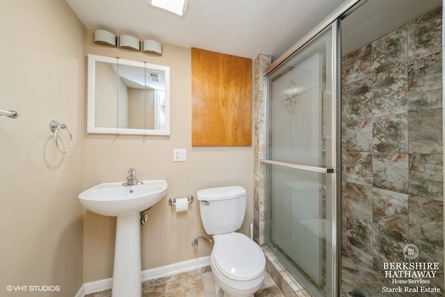 full bath featuring baseboards, toilet, and a stall shower