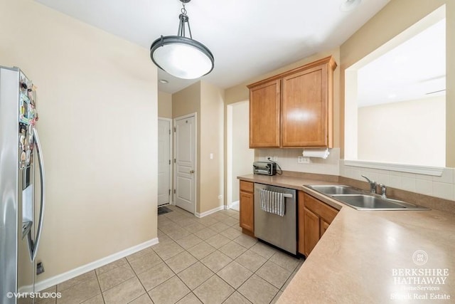 kitchen featuring light tile patterned flooring, a sink, stainless steel appliances, light countertops, and pendant lighting