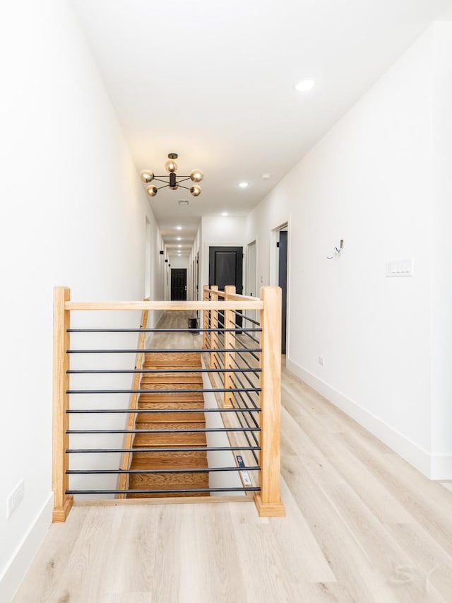 interior space with baseboards, wood finished floors, and an upstairs landing