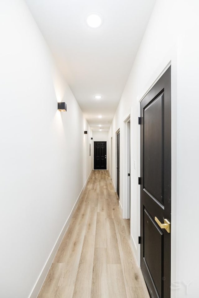 corridor featuring light wood finished floors, baseboards, and recessed lighting