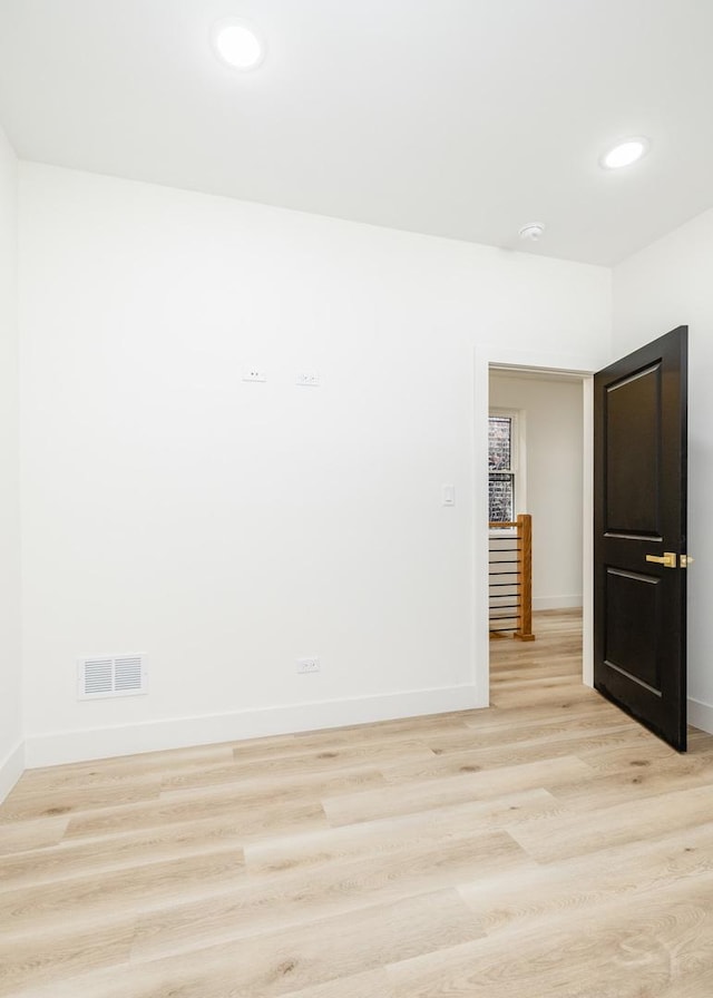 spare room featuring recessed lighting, light wood-type flooring, visible vents, and baseboards