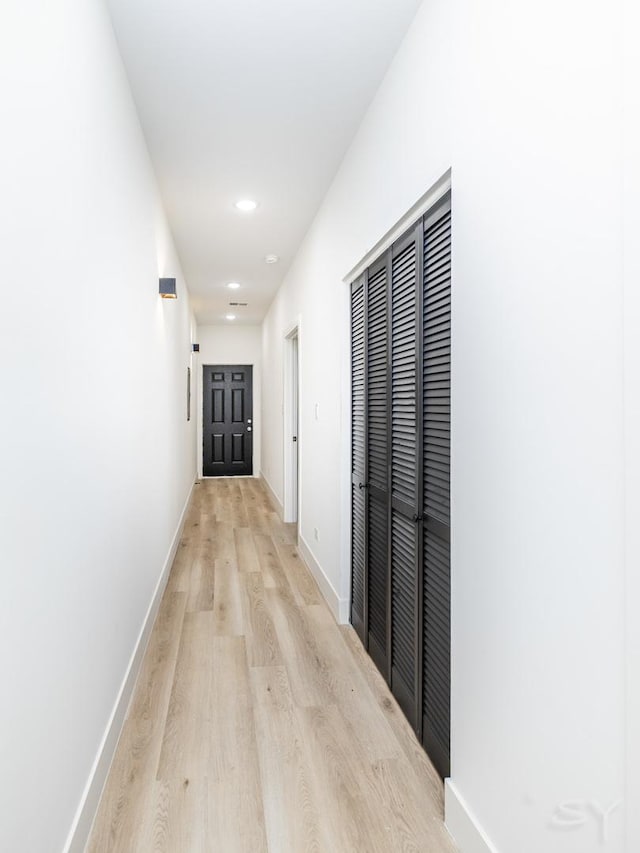 hallway with light wood-style flooring, baseboards, and recessed lighting