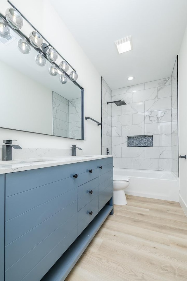 bathroom featuring bathtub / shower combination, vanity, toilet, and wood finished floors