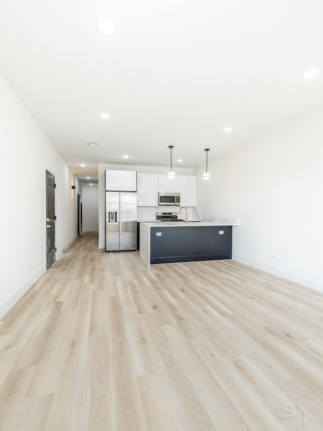 kitchen featuring light wood finished floors, stainless steel appliances, recessed lighting, light countertops, and white cabinets