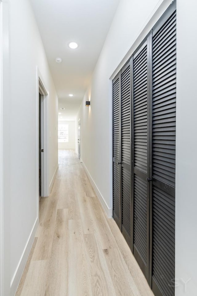 hall with light wood-type flooring, baseboards, and recessed lighting