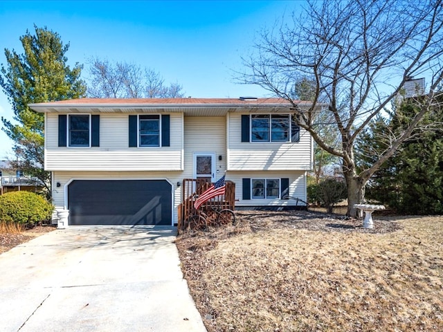 split foyer home with concrete driveway and an attached garage