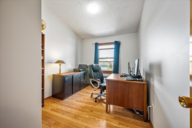 home office featuring light wood-type flooring, a textured ceiling, and vaulted ceiling