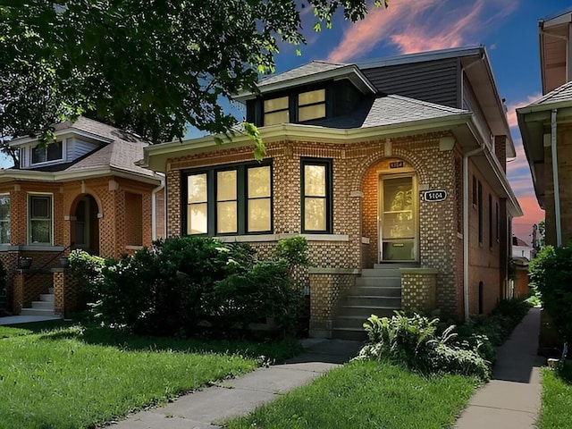 view of front of property with a yard and brick siding